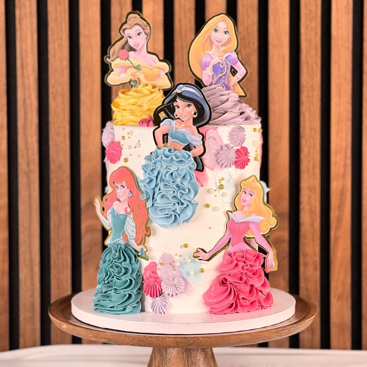 Disney Princess tårta- Denna underbara Disney Princess-tårta är perfekt för små prinsessors födelsedagar! Med vackra handgjorda dekorationer av älskade prinsessor som Belle, Ariel, Jasmine, Aurora och Rapunzel, blir denna tårta en dröm för alla Disney-fans. Tårtan är elegant dekorerad med krämiga rosetter och detaljer i pastellfärger. Perfekt för att skapa magiska stunder på varje barnkalas. Beställ din tårta idag och förvandla firandet till en sagolik upplevelse! Bilder är ej ätbara och plockas enkelt bort