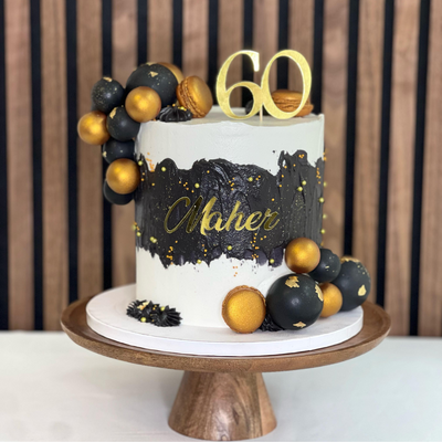 Golden Elegance tårta- Golden Elegance tårta, perfekt för speciella tillfällen! Denna lyxiga tårta är dekorerad med macarons och kulor, vilket gör den idealisk för att fira med stil. Beställ din tårta idag. Bollarna är ej ätbara och plockas enkelt bort innan servering. ÄR DU ALLERGISK? KONTAKTA OSS OM ALLERGENER.040-104088 eller info@cocodrip.se -Cocodrip - Tårta och Baktillbehör