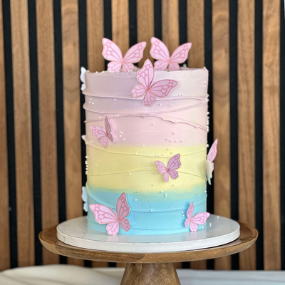 Pastel Dream tårta- Pastel Dream – en magisk tårta i mjuka pastellfärger, dekorerad med söta fjärilar. Perfekt för barnkalas, dop och andra festliga tillfällen. Låt denna drömska tårta bli höjdpunkten på din nästa fest. Beställ nu och njut av en färgglad smakupplevelse! Dekorationerna är ej ätbara och plockas enkelt bort innan servering. ÄR DU ALLERGISK? KONTAKTA OSS OM ALLERGENER.040-104088 eller info@cocodrip.se -Cocodrip - Tårta och Baktillbehör