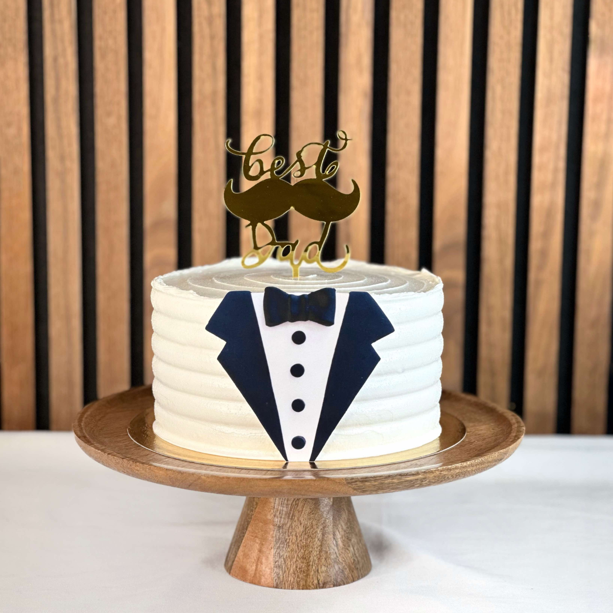 Fars dag tårta- Elegant och stilren fars dag-tårta i form av en smoking, med en guldig "Best Dad"-tårtdekoration på toppen. Perfekt för att hylla pappor på deras speciella dag. 10-12 bitar. Vaniljbottnen - vaniljmousse - chokladmousse och chokladcrunch. Bilden och caketoppern är ej ätbara och plockas enkelt bort innan servering. ÄR DU ALLERGISK? KONTAKTA OSS OM ALLERGENER.040-104088 eller info@cocodrip.se -Cocodrip - Tårta och Baktillbehör