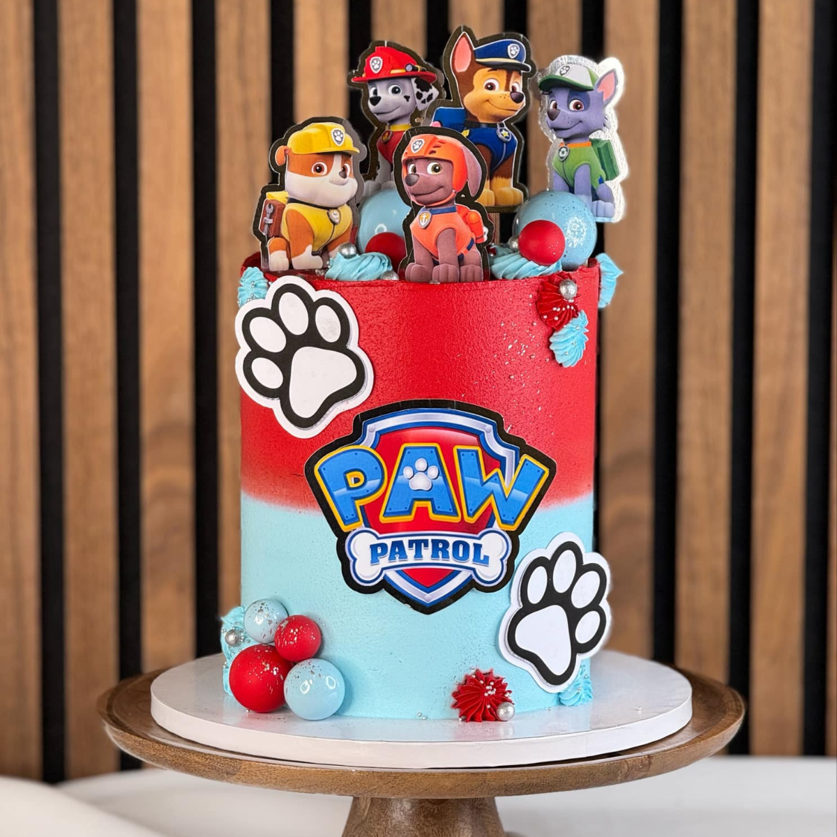 Paw Patrol tårta- Denna häftiga Paw Patrol-tårta är perfekt för alla små äventyrslystna barn! Med sina färgstarka och detaljerade dekorationer av populära karaktärer som Marshall, Chase, Rubble och Zuma, kommer denna tårta att göra succé på barnkalaset. Den är designad i rött och blått för att matcha Paw Patrol-temat och är en riktig fröjd för ögat. Låt denna tårta bli höjdpunkten på ditt barns födelsedagsfest – beställ idag och ge små hjältar en oförglömlig upplevelse! Bilderna & bollarna är ej ätbara och 